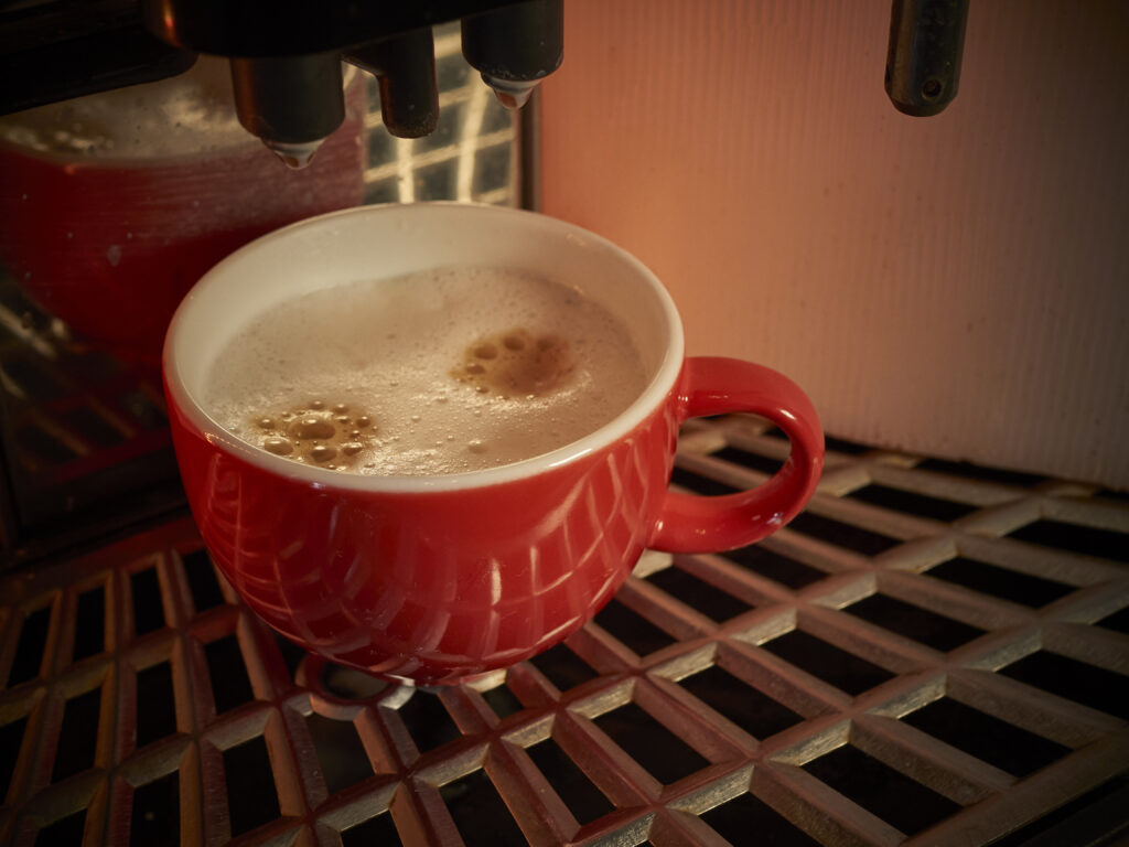Eine Kaffeetasse unter der Kaffeemaschine .... leckerer Kaffee, frisch gezapft.
