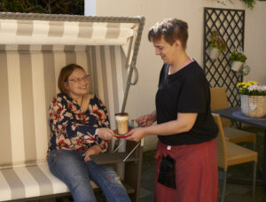 Ein Gast sitzt in unserem Strandkorb und bekommt einen leckeren Latte Macciato.